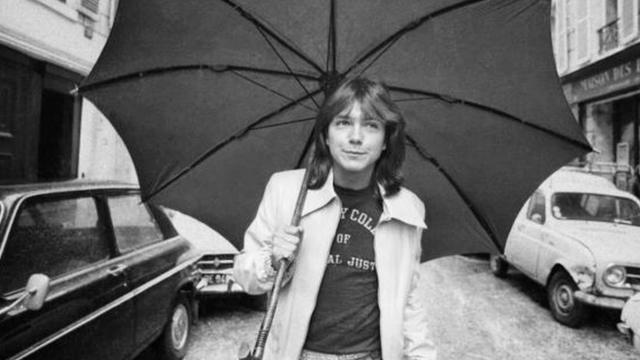 David Cassidy caminando en una calle de Londres con un paraguas (30 de abril de 1974)
