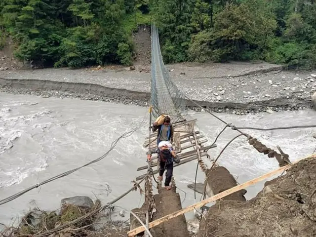 नेपालको मनाङ जिल्लाको चामे गाउँपालिकामा कोतोमा रहेको झोलुङ्गे पुल बाढीका कारण क्षतिग्रस भएपछि स्थानीयवासीहरू नारफू र सदरमुकाम आवतजाव गर्न यही भत्किएको पुल प्रयोग गर्न बाध्य छन्