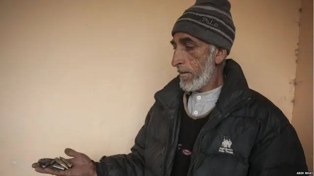 Mohammad Yaqoob holds empty bullet shells in his palm.