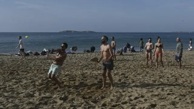 People play at a beach near Athens