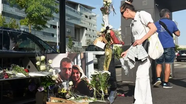 Woman lays flowers next to a picture of the driver killed
