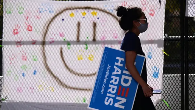 supporter walks past sign