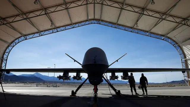 Imagen de un dron con dos personas al lado.