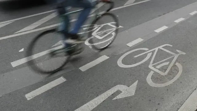 மதிவண்டி ஓட்டி செல்லும் ஒருவர்