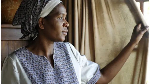 Mujer negra mira a través de una ventana