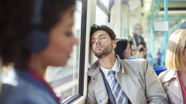 Hombre con los ojos cerrados en un medio de transporte.