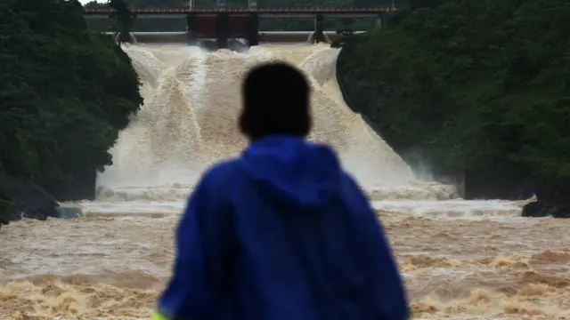 Warga menyaksikan aliran air dari Bendungan Bili-bili di Gowa, Sulawesi Selatan, Rabu (23/1/2019). Ketinggian air di pintu air Bendungan Bili-bili mencapai 101,36 meter akibat curah hujan tinggi yang menyebabkan terjadinya luapan di bantaran Sungai Jenneberang.