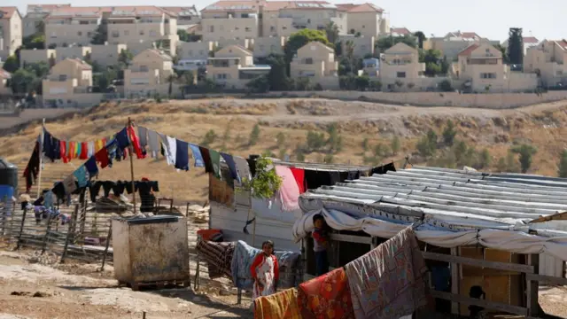 File photo showing Palestinian children playing outside their dwelling in al-Eizariya, near the Jewish settlement of Maale Admumim in the occupied West Bank (20 July 2019)