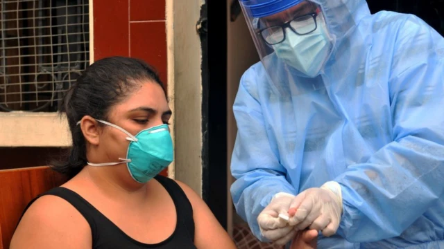 Persona atendida por médico, ambos usan mascarillas