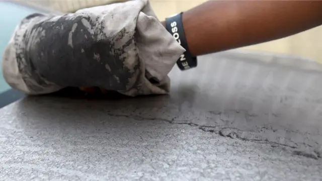 कार साफ़ करता एक व्यक्ति.