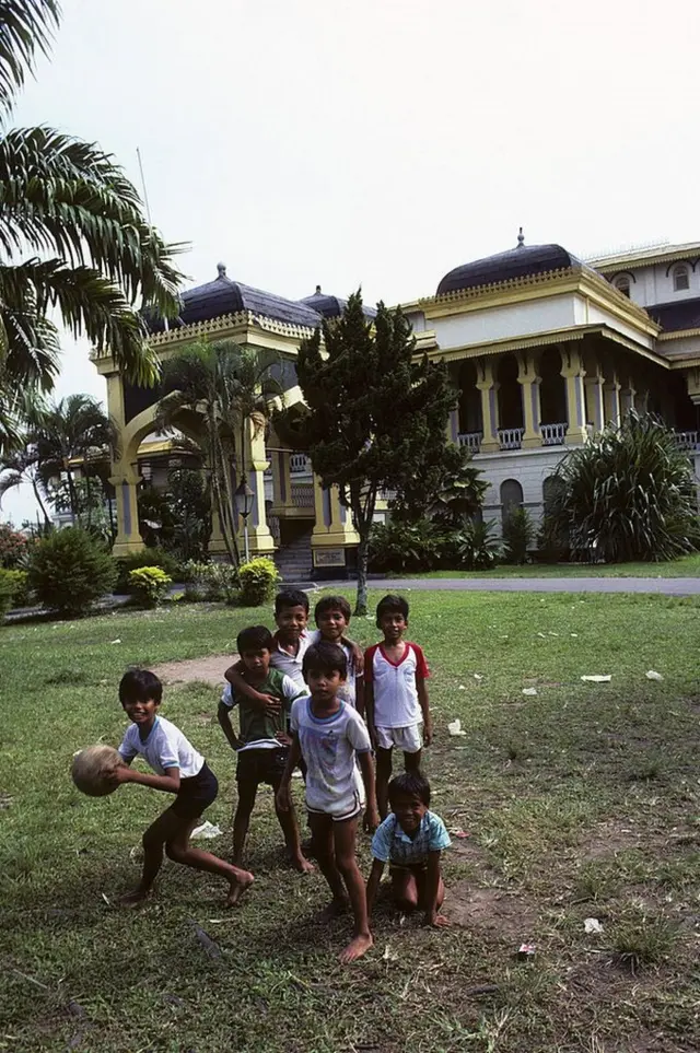 Bocah bermain sepak bola di depan Istana Maimun, Medan, 1988.
