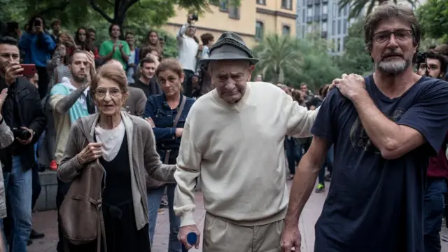 A ninety-year old man is cheered and clapped by the crowd as he leaves after casting his referendum vote at the Escola Industrial of Barcelona school polling station on October 1, 2017 in Barcelona, Spain.