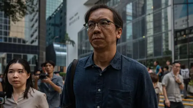 Бывший редактор Stand News Чунг Пуй-Куен покидает здание суда после приговора