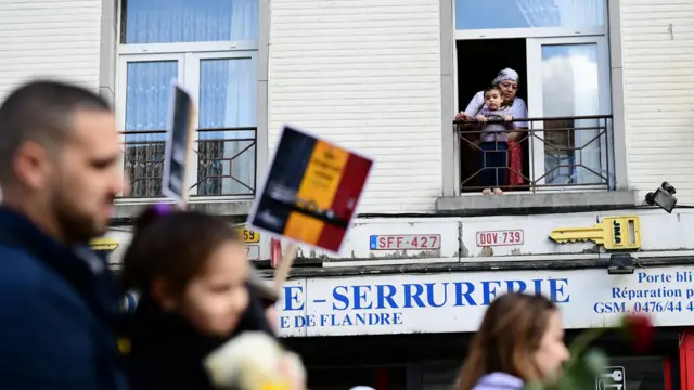 Madre musulmana con un niño mirando desde una ventana en Bélgica