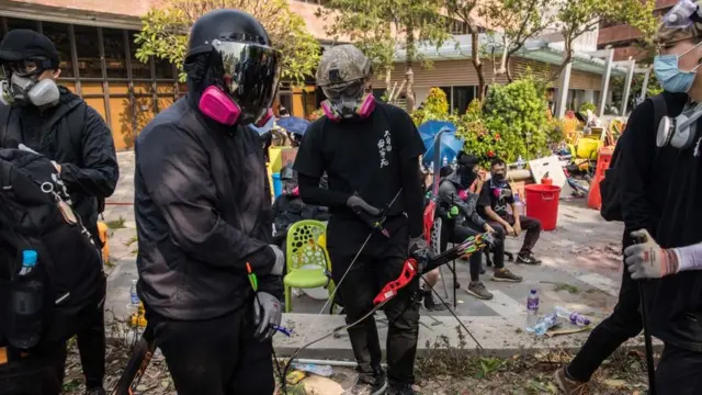 Manifestantes con arcos y flechas.