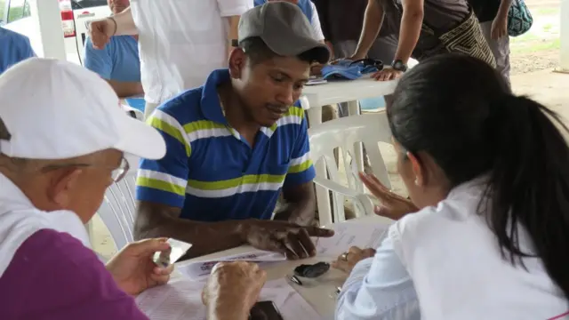 Guerrillero con funcionarios del gobierno.