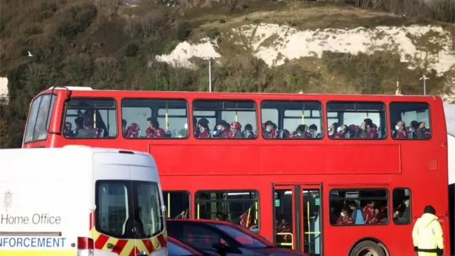 Migrants rescued from the English Channel by UK Border Force sit on a bus after arriving in the early hours at Dover harbour, Britain, November 25, 2021