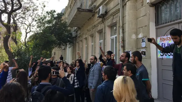 Люди с поднятыми руками у здания суда