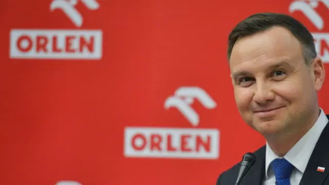 Анджей Дуда на фоне логотипа PKN Orlen