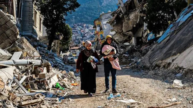 صورة لعائلة نجت من الزلزال وسط الدمار في سوريا