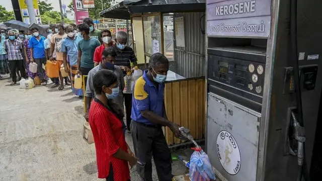 People stand in a queue to buy kerosene oil used in cooking stoves in Colombo on August 31, 2021 following Sri Lanka's declaration of state of emergency over food shortages as private banks ran out of foreign exchange to finance imports.