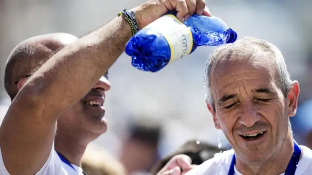 Мужчины поливают головы водой