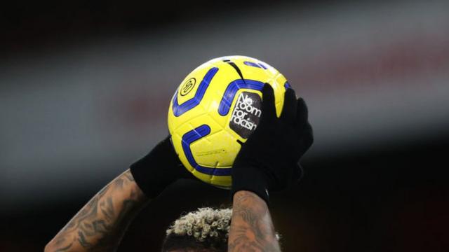 Player with a match ball containing an anti-racism message