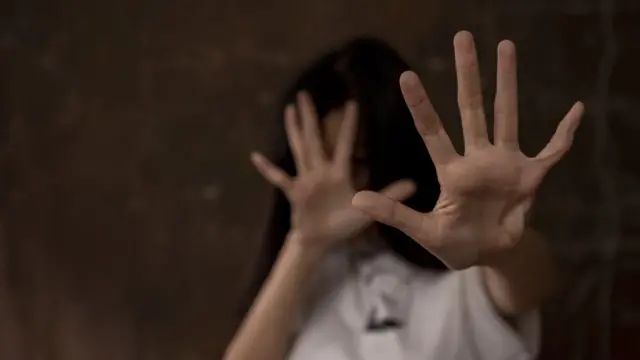 Una persona se defiende con las manos extendidas