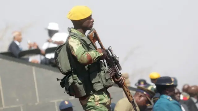 An armed member of the Zimbabwe National Army (ZNA) stands guard