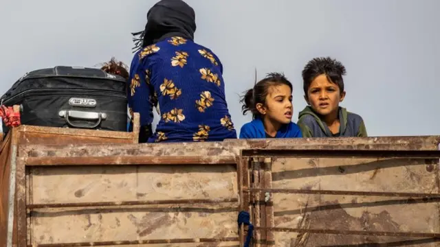 सीरिया में घर छोड़कर जाते बच्चे