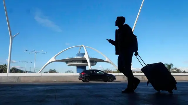 Valizini çeken yolcu