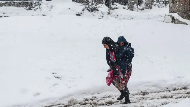 Küçükpazar rayonunda Suriyalı qadın oğlunu daşıyır.