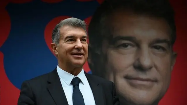 Joan Laporta stands in front of a billboard with his image on it