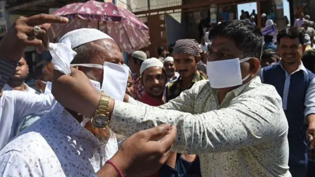 અમદાવાદમાં 20 માર્ચ શુક્રવારે જુમ્માની નમાઝ પહેલાં જામા મસ્જિદની બહાર માસ્ક આપતા લોકો