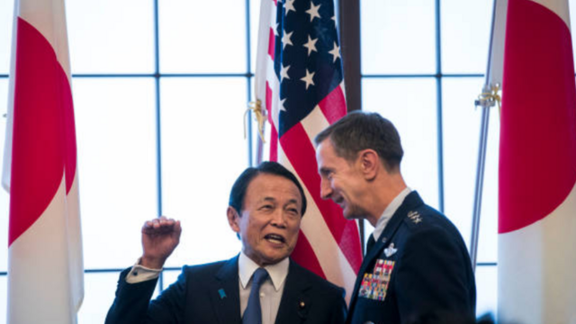 Japan's deputy prime minister Taro Aso (L) chats with Commander of the US Forces in Japan (USFJ), Lieutenant General Kevin Schneider (R) during the 60th anniversary commemorative reception of the signing of the Japan-US security treaty at Iikura Guesthouse in Tokyo on January 19, 2020.