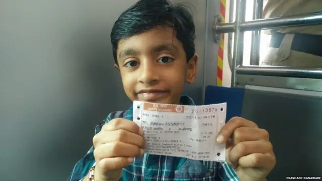 तिकीट दाखवणारा लहान मुलगा