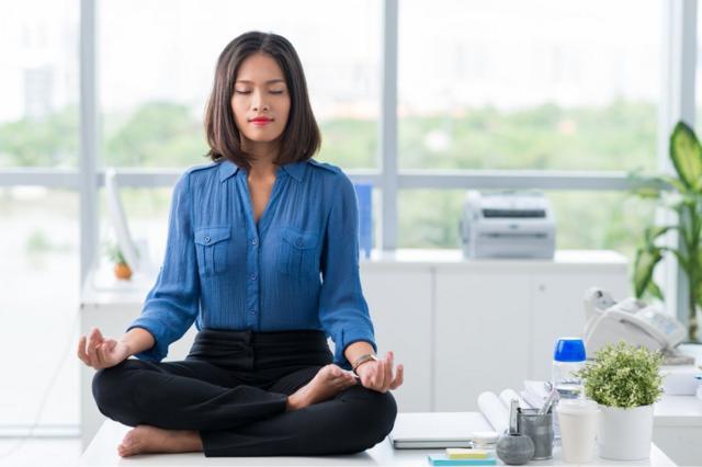 Mulher meditando na mesacomo ganhar na bet 365trabalho