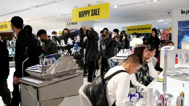 在商场，示威者一边抗场，市民一边购物。