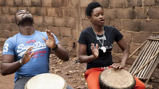 Salimata, jouant au Djembé avec son frère.