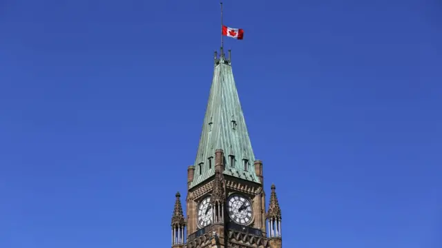 La bandera canadiense ondea a media asta en lo alto de la Torre de la Paz, en Ottawa.