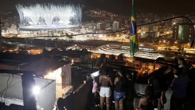 Habitantes de las favelas durante la inauguración ven el estadio Maracaná de lejos