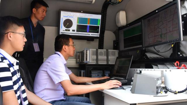 6月7日，在山东省济南中学高考考点，3名济南市无线电管理办公室的工作人员在车内进行无线电监测工作。