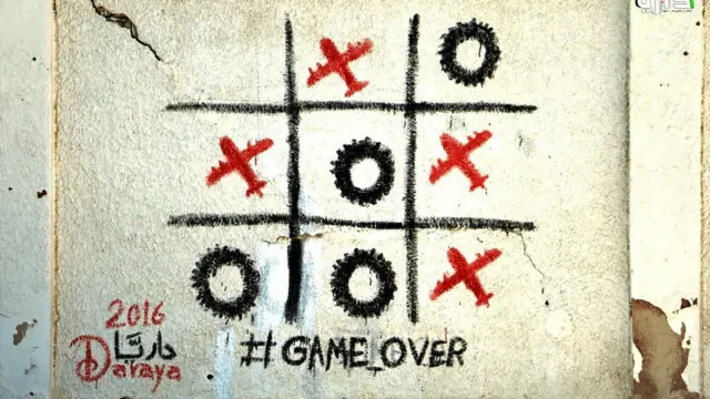 Abu Malik al-Shami'nin Deraya'daki son resmi, Halep'teki hava saldırılarına gönderme yapıyor. X'ler Rusya ve Suriye savaş uçaklarını, O'lar ise Suriyeli çocukların duman perdesi yapmak için yaktıkları lastikleri temsil ediyor.