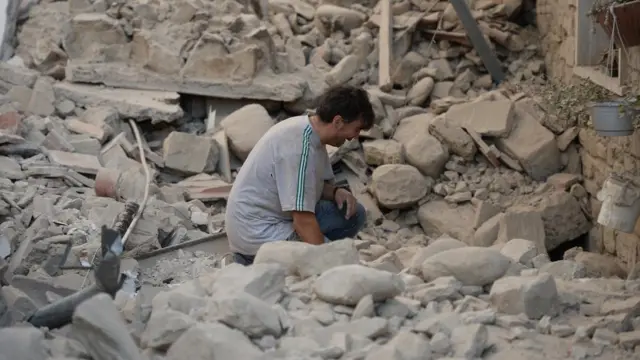 Un hombre se lamenta luego del terremoto que dejó en escombros a muchas casas.
