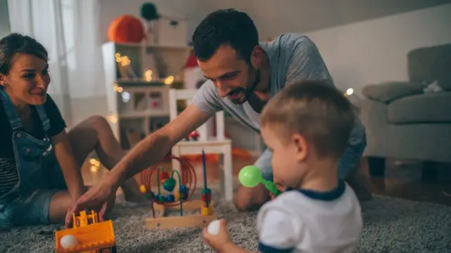 Pais brincando com filho