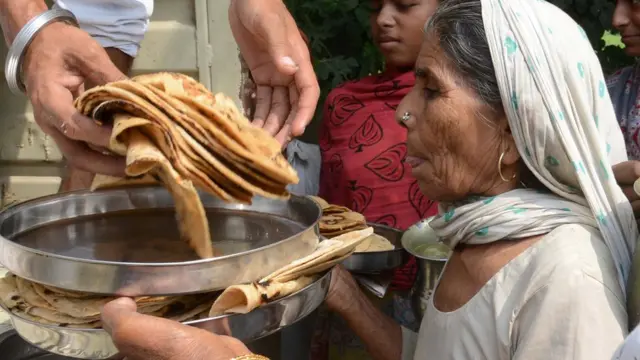 रोटी ले रही महिला