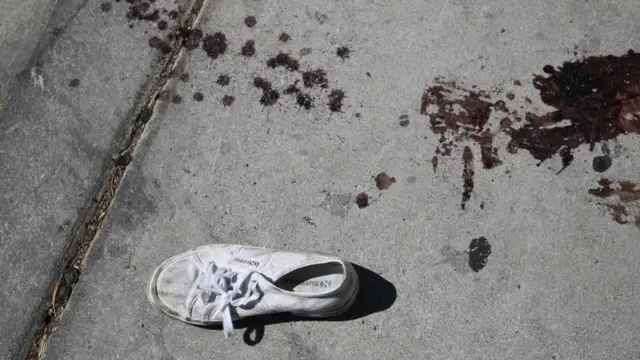 Zapatilla con sangre en el suelo.