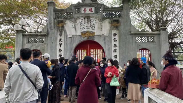 Đền Ngọc Sơn chỉ mở cửa đón từng tốp 10 người đi lễ mỗi lượt nên khá nhiều người phải đợi bên ngoài.