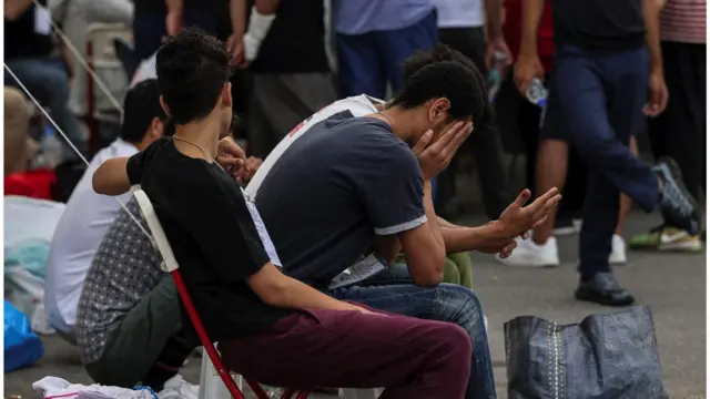 Survivors of a deadly shipwreck wait to board a bus as they are transferred to Athens from the port of Kalamata, Greece on 16 June