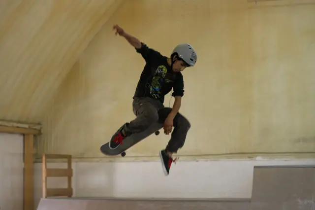 Instruktor demonstrira flip, tehniku koja uključuje okretanje daske nogom u vazduhu.